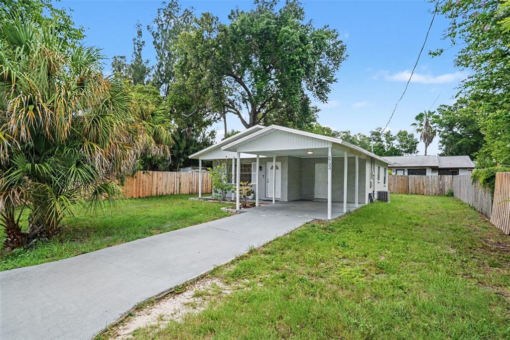 A kitchen features white cabinets, stainless steel appliances, tile flooring, and a small dining area — 5733 66TH LANE N, ST PETERSBURG, FL