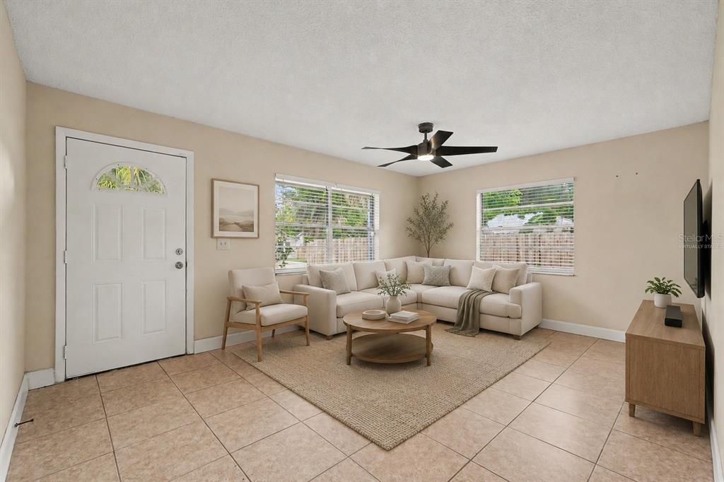 The exterior of a white concrete block house features a backyard patio with dining furniture — 5733 66TH LANE N, ST PETERSBURG, FL