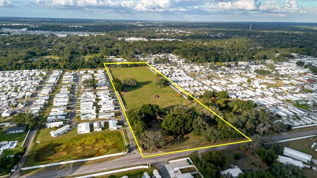 An aerial view shows a large, rectangular vacant lot outlined in yellow near residential homes — 37435 CHANCEY ROAD, ZEPHYRHILLS, FL