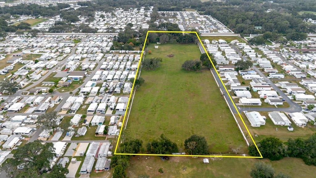 An aerial view shows a large, rectangular vacant lot surrounded by a mobile home park — 37435 CHANCEY ROAD, ZEPHYRHILLS, FL