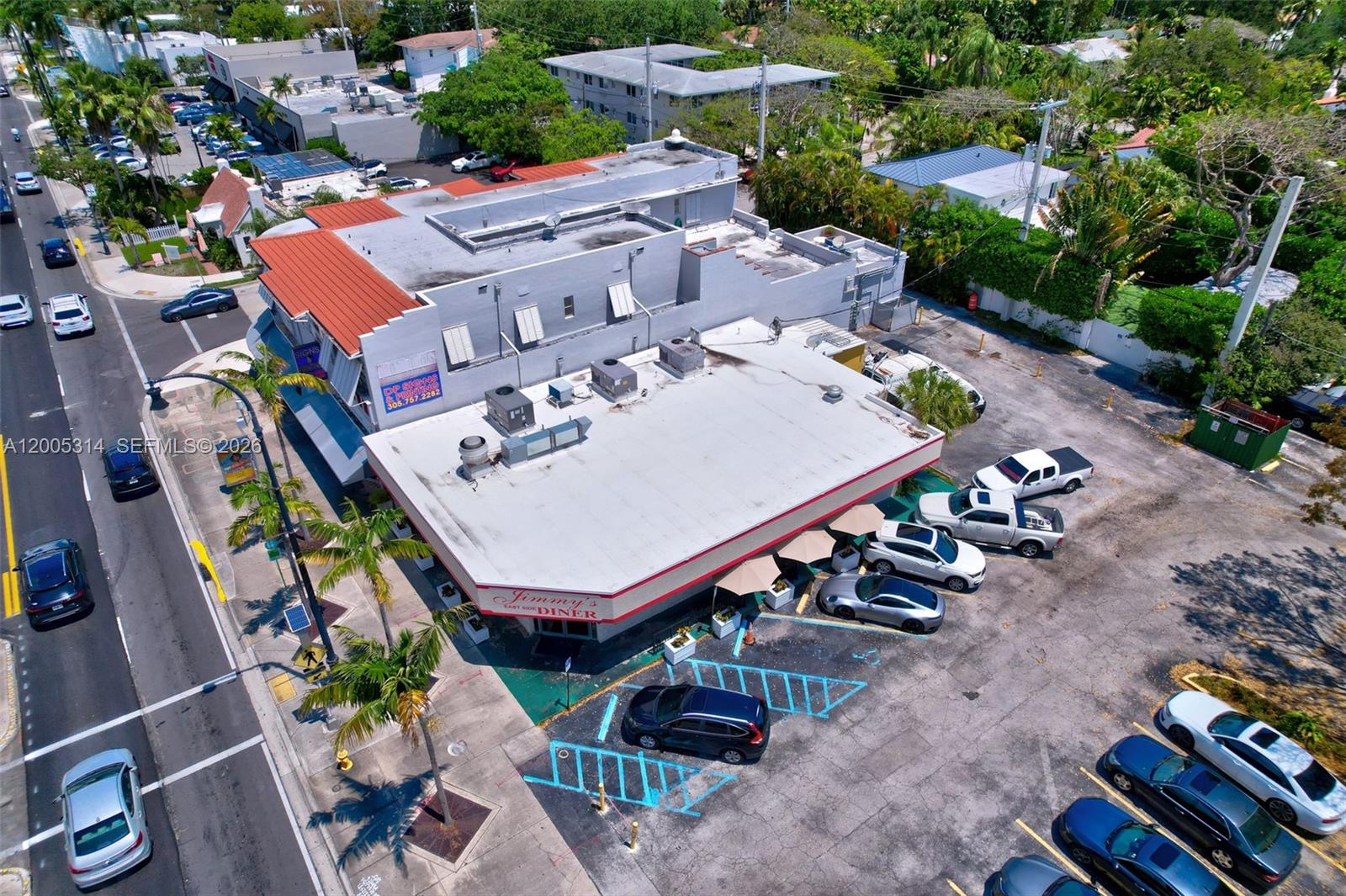 An aerial view shows a corner commercial building with a parking lot and street traffic — 7201 Biscayne Blvd, Miami FL 33138, MIAMI, FL
