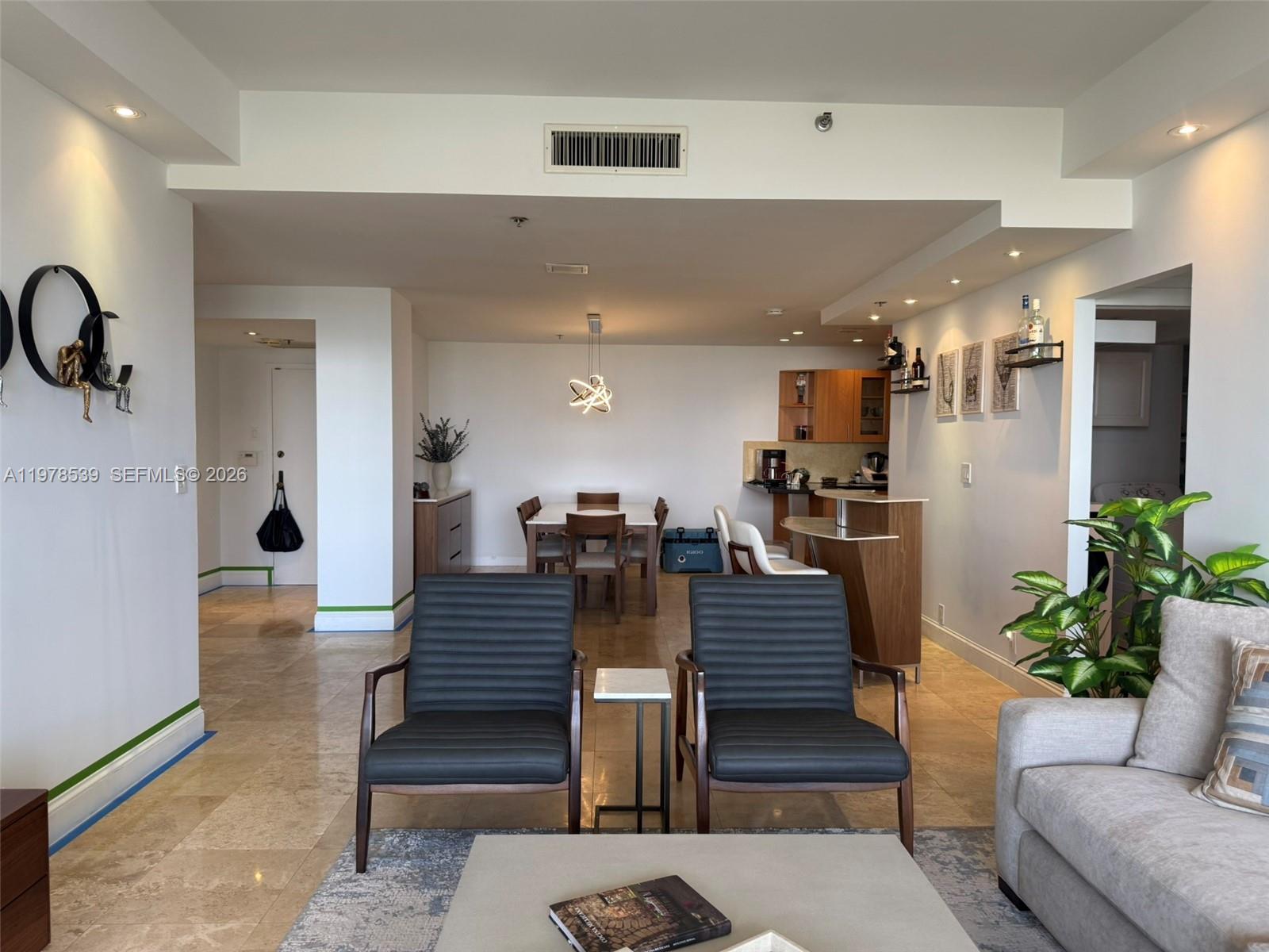 A living room and dining area feature tile floors, modern furniture, and an open kitchen — 251 Crandon Blvd # 606, Key Biscayne FL 33149, KEY BISCAYNE, FL