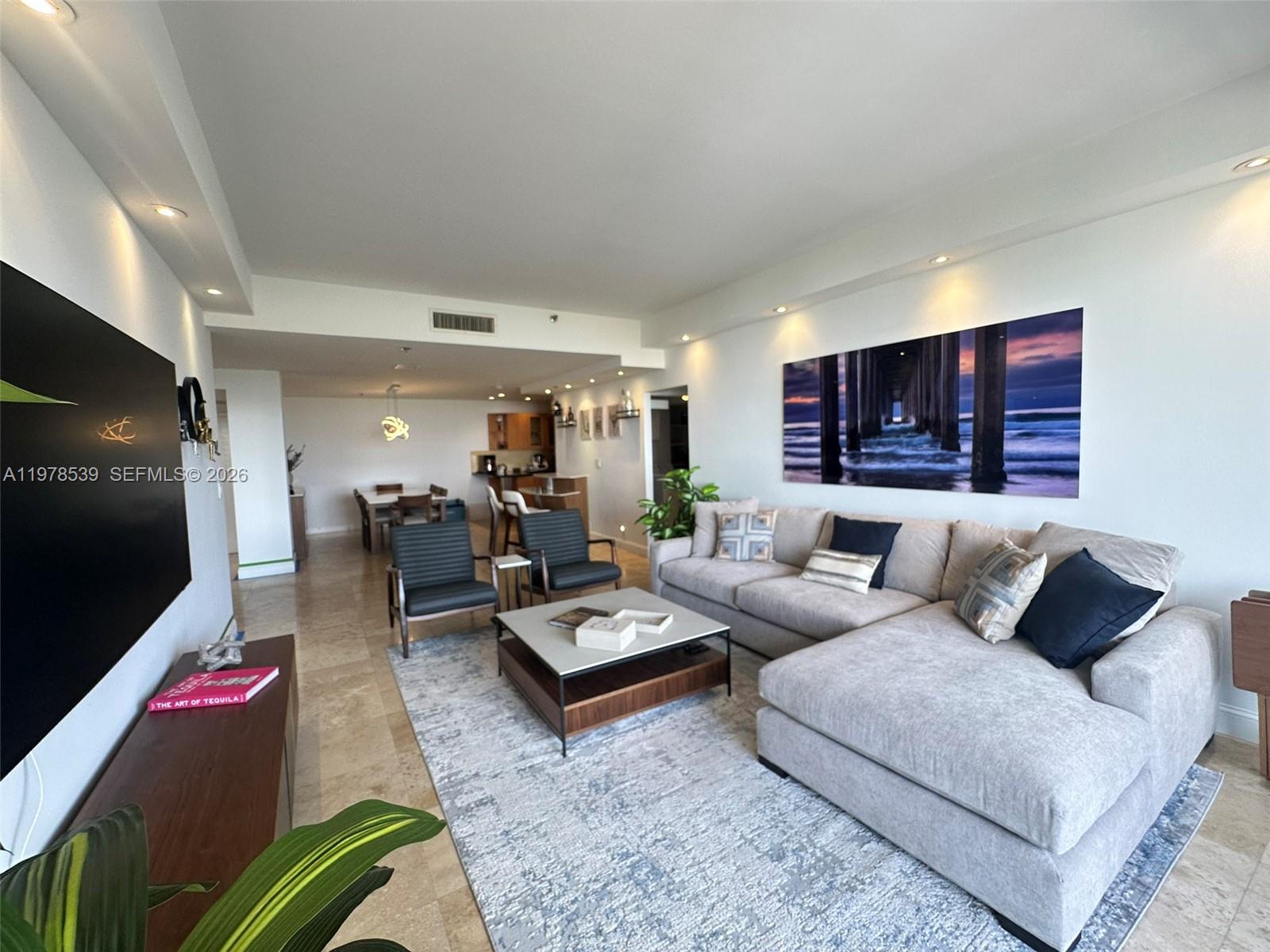 A modern living room features a large sectional sofa, two armchairs, and a dining area — 251 Crandon Blvd # 606, Key Biscayne FL 33149, KEY BISCAYNE, FL