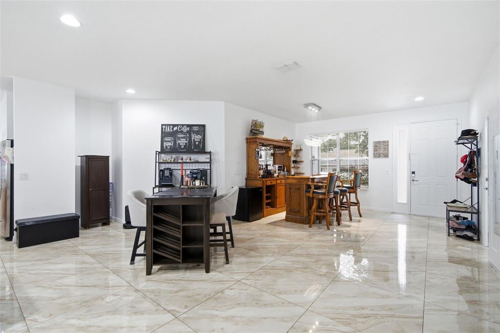 A spacious room features light-colored tile flooring, a coffee station, and a wooden home bar — 508 DEBRA DRIVE, BRANDON, FL