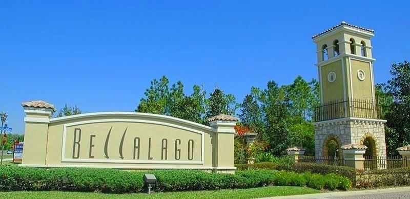 A beige community entrance sign with a tall tower stands against a clear blue sky — 920 WINDLASS COURT, KISSIMMEE, FL