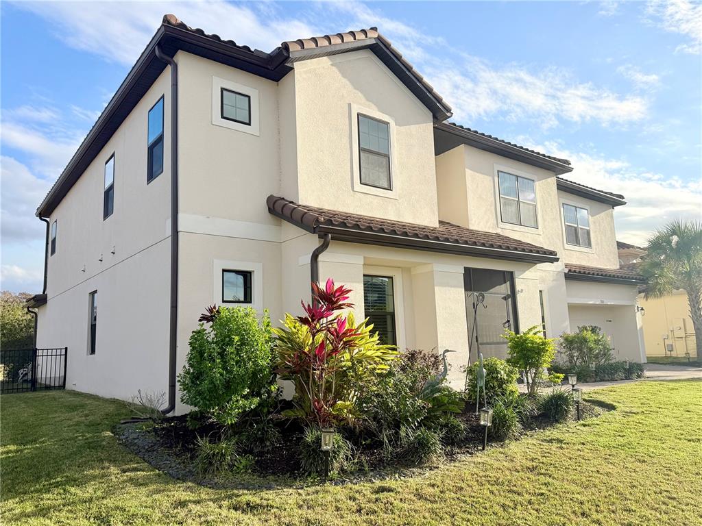 A two-story stucco house with a tile roof and a landscaped front yard — 920 WINDLASS COURT, KISSIMMEE, FL