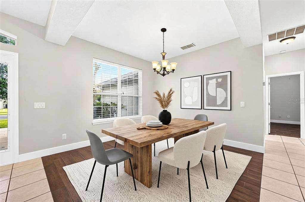 A dining room features a wooden table, mixed chairs, a chandelier, and framed wall art — 561 CAREY WAY, ORLANDO, FL