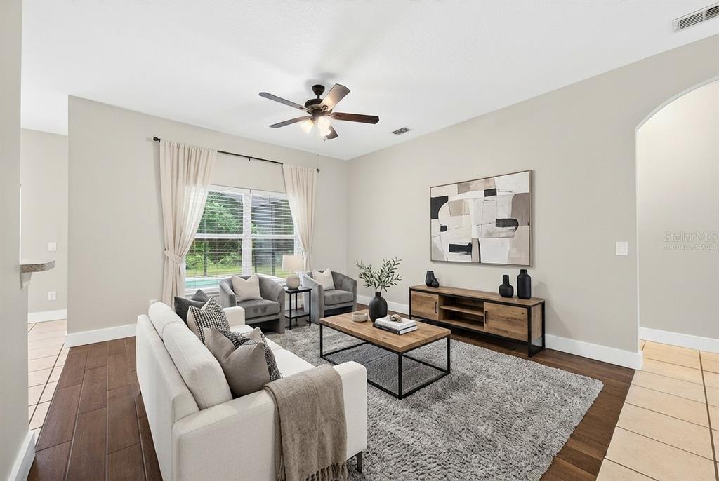 A living room features a white sofa, two armchairs, a wooden coffee table, and flooring — 561 CAREY WAY, ORLANDO, FL
