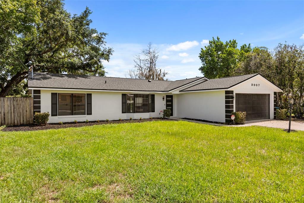 A single-story white house with a dark roof, black shutters, and an attached garage — 3007 FAYSON CIRCLE, DELTONA, FL
