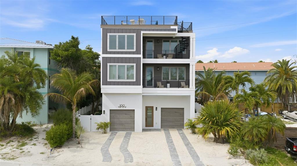 A three-story modern house with two garages, balconies, and a rooftop deck — 100 12TH STREET N, BRADENTON BEACH, FL