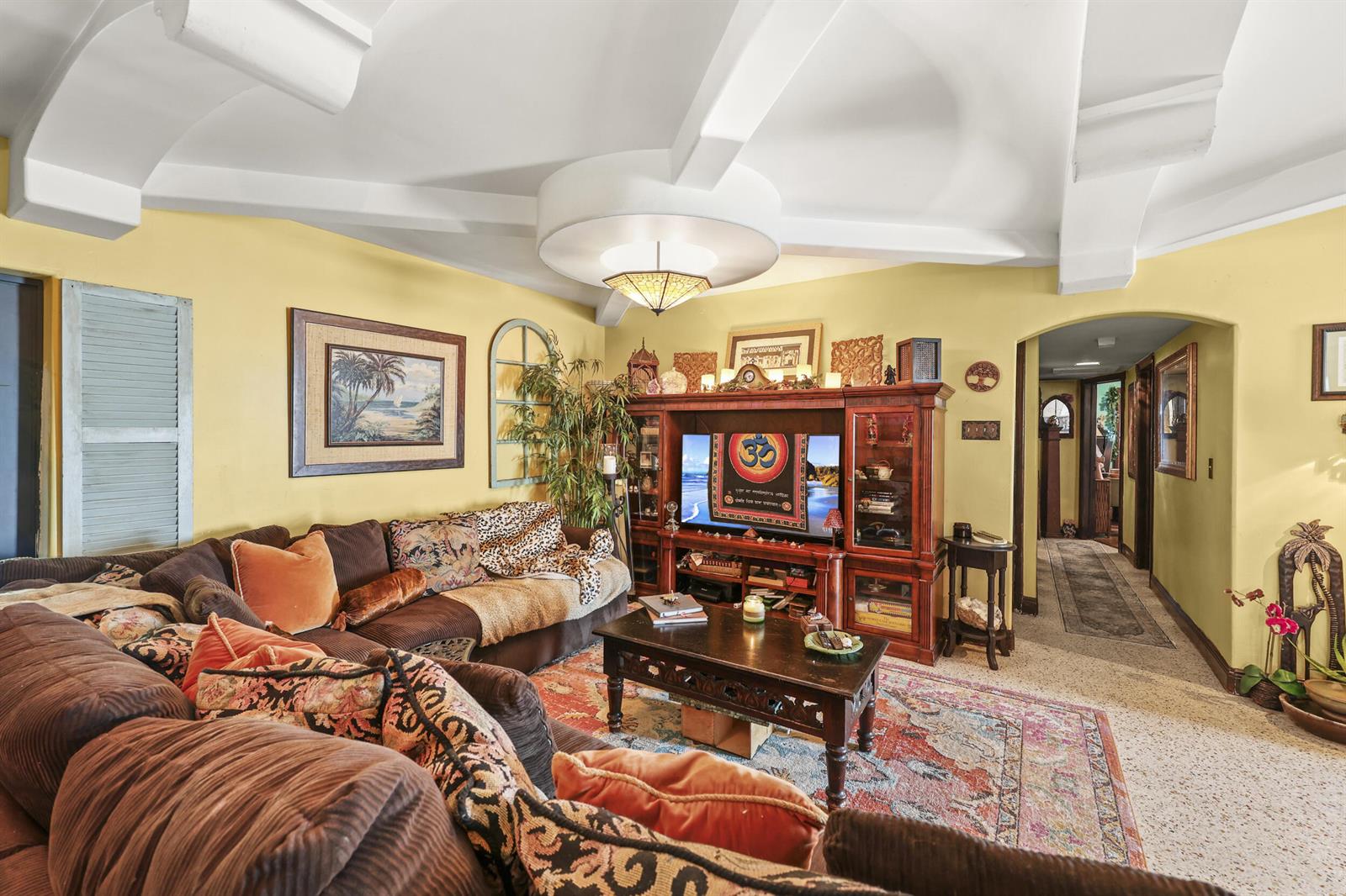 A living room features a coffered ceiling, yellow walls, a brown sectional, and an entertainment center — 112 San Juan Drive, Palm Springs FL 33461, PALM SPRINGS, FL