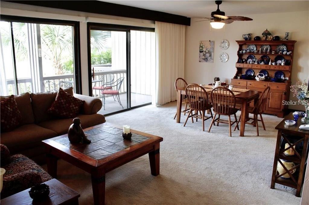 A living and dining area features a brown sofa, tile-top coffee table, and wooden hutch — 901 TENNIS WAY UNIT 3141, HAINES CITY, FL