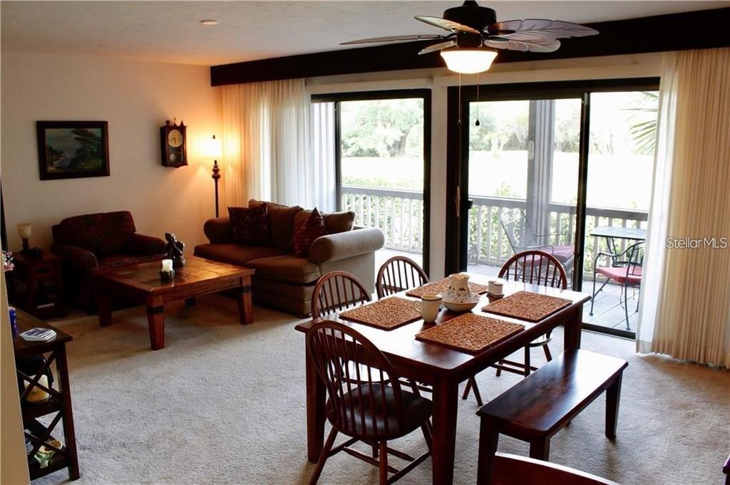 A living and dining area features carpeted floors, a ceiling fan, and sliding glass balcony doors — 901 TENNIS WAY UNIT 3141, HAINES CITY, FL