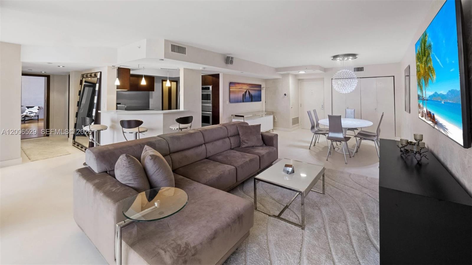 A living room features a large sectional sofa, a dining area, and an open kitchen — 1900 Sunset Harbour Dr # 2008, Miami Beach FL 33139, MIAMI BEACH, FL