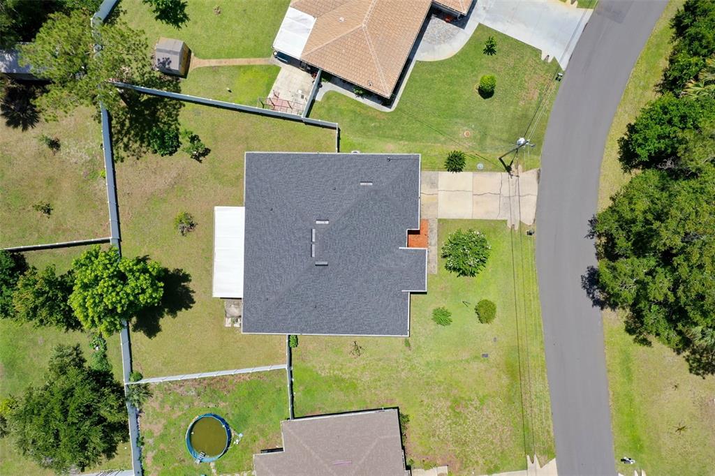 An aerial view shows a house with a dark shingled roof and surrounding yard — 25 PILLORY LANE, PALM COAST, FL