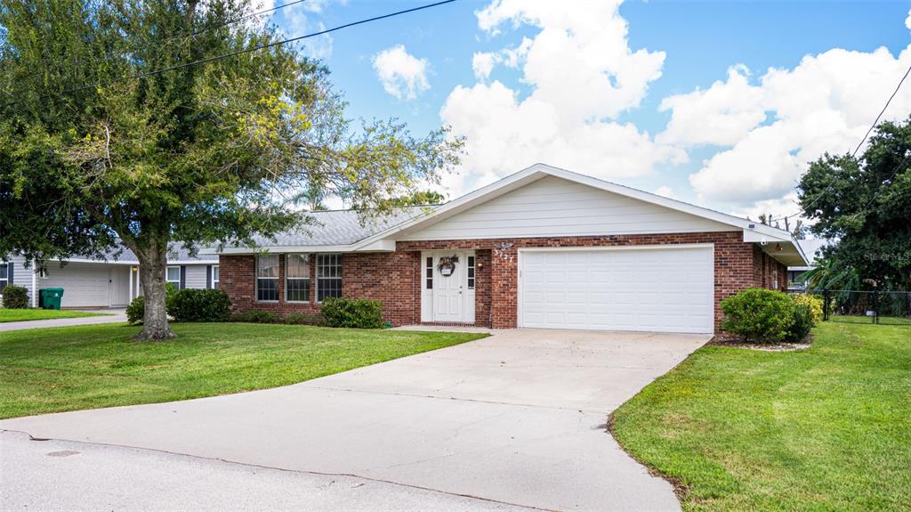 A single-story brick house with a white garage door and a concrete driveway — 3127 SHANNON DRIVE, PUNTA GORDA, FL