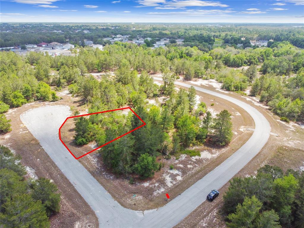 An aerial view shows a vacant, wooded residential lot outlined in red on a cul-de-sac — 602 HOMOSASSA WAY, KISSIMMEE, FL