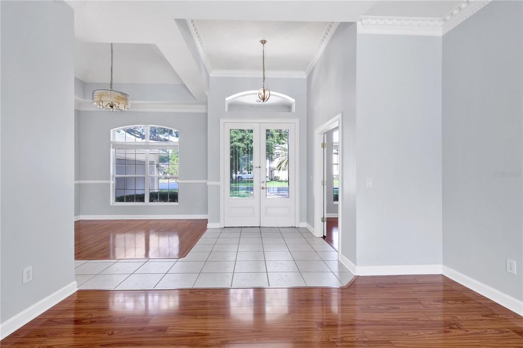 An entryway with tile flooring, double front doors, and adjacent rooms with hardwood floors — 1337 BALLENTYNE PLACE, APOPKA, FL