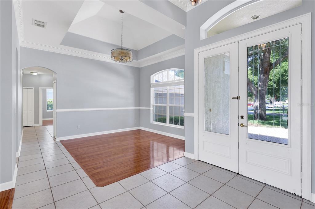An entryway with tile flooring, a wood-floored dining area, and a double front door — 1337 BALLENTYNE PLACE, APOPKA, FL