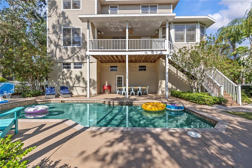 A multi-story house with a backyard pool, covered patio, and an outdoor staircase — 897 POINT SEASIDE DRIVE, CRYSTAL BEACH, FL