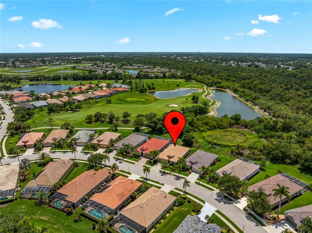 An aerial view shows a residential neighborhood with houses, a golf course, and ponds — 5435 BLUE HERON CIRCLE, NORTH PORT, FL