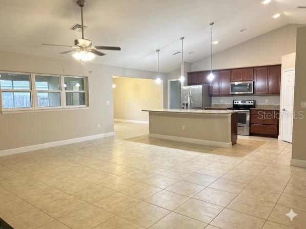 An open-concept kitchen with dark wood cabinets and a breakfast bar overlooks a tiled living area — 9670 SW 42ND AVENUE, OCALA, FL