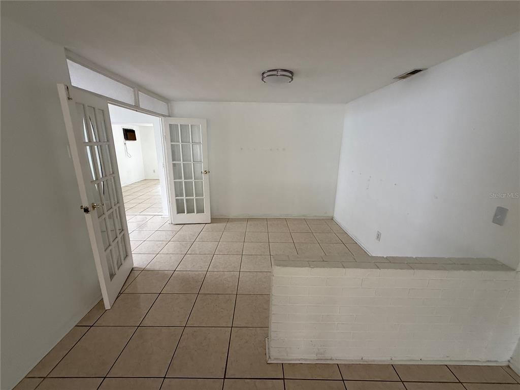 An interior room features white walls, tile flooring, and a white brick half-wall partition — 1270 8TH AVENUE NE, LARGO, FL