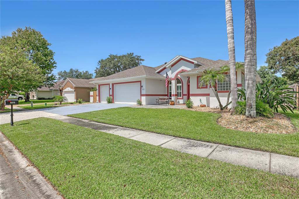 A single-story house with a white exterior, red trim, and a two-car garage — 4373 FLETCHER LANE, TITUSVILLE, FL