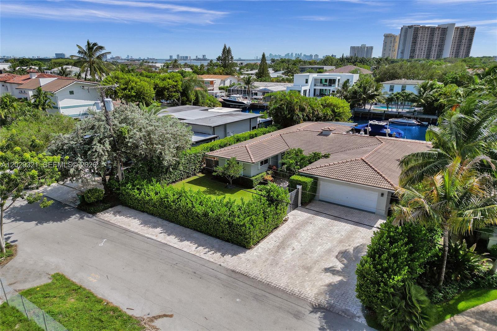 An aerial view shows a single-story house with a tiled roof, driveway, and landscaped yard — 1912 NE 119th Rd # 0, North Miami FL 33181, NORTH MIAMI, FL