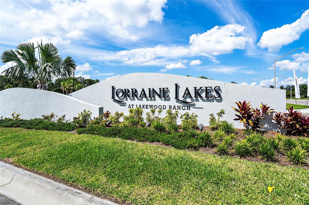 A white monument sign for Lorraine Lakes at Lakewood Ranch stands in a grassy area — 16228 TRADEWIND TERRACE, LAKEWOOD RANCH, FL