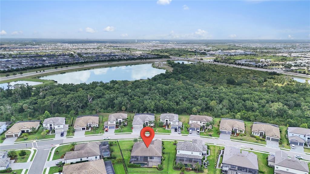 An aerial view shows a residential neighborhood with a marked house and a nearby lake — 16228 TRADEWIND TERRACE, LAKEWOOD RANCH, FL