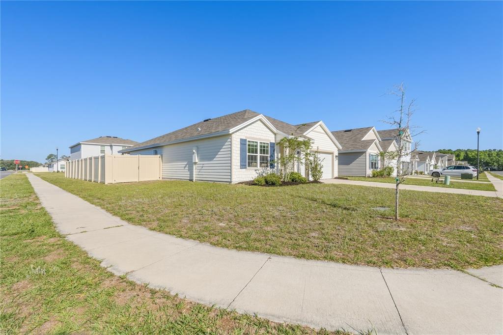 A single-story house with light siding, blue shutters, and a white privacy fence — 2114 NW 246TH TERRACE, NEWBERRY, FL