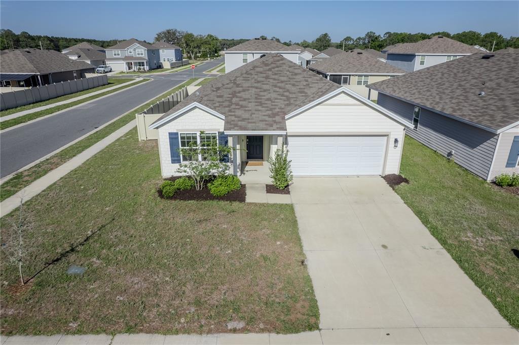 An aerial view of a single-story suburban house with a concrete driveway and shingled roof — 2114 NW 246TH TERRACE, NEWBERRY, FL