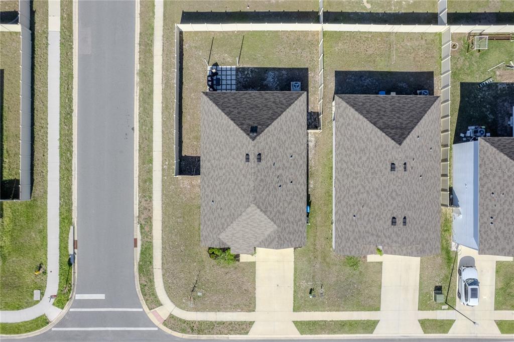 An aerial view shows two suburban houses with driveways, fenced backyards, and a nearby street — 2114 NW 246TH TERRACE, NEWBERRY, FL