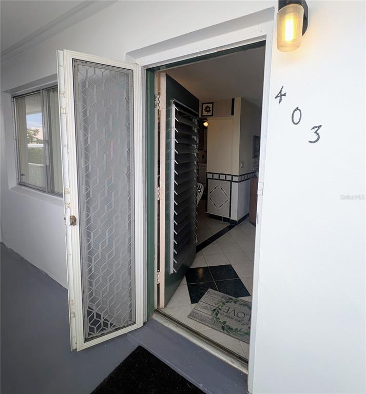 An open door reveals an entryway with tiled floors and a louvered interior door — 8055 112TH STREET UNIT 403, SEMINOLE, FL