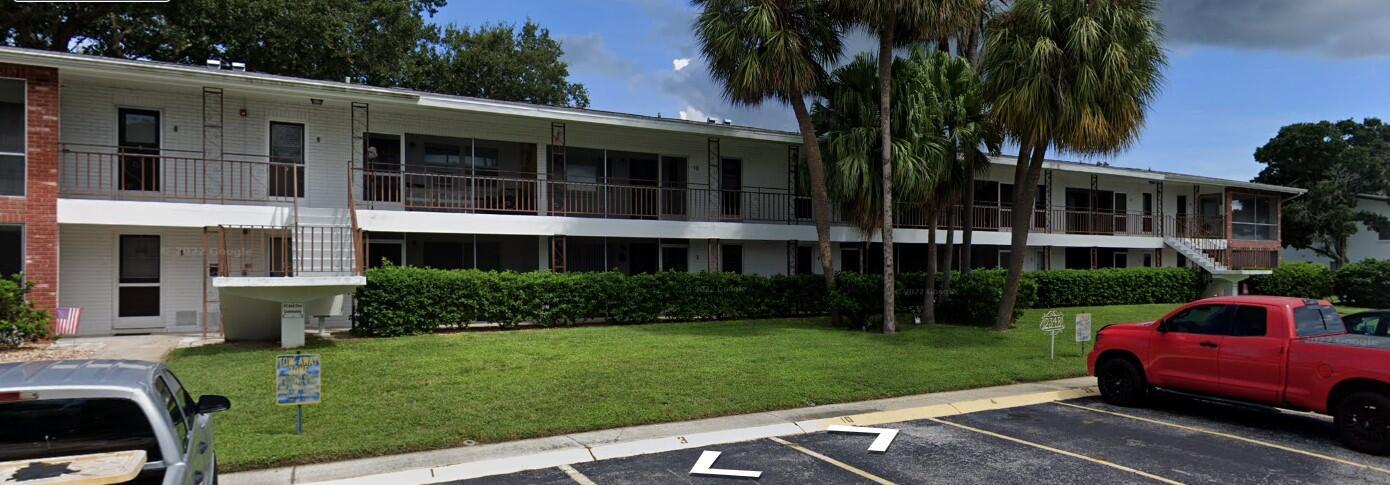 A two-story apartment building with white brick walls, a balcony, and a parking lot — 2348 Shelley Street # 1, Clearwater FL 33765, CLEARWATER, FL