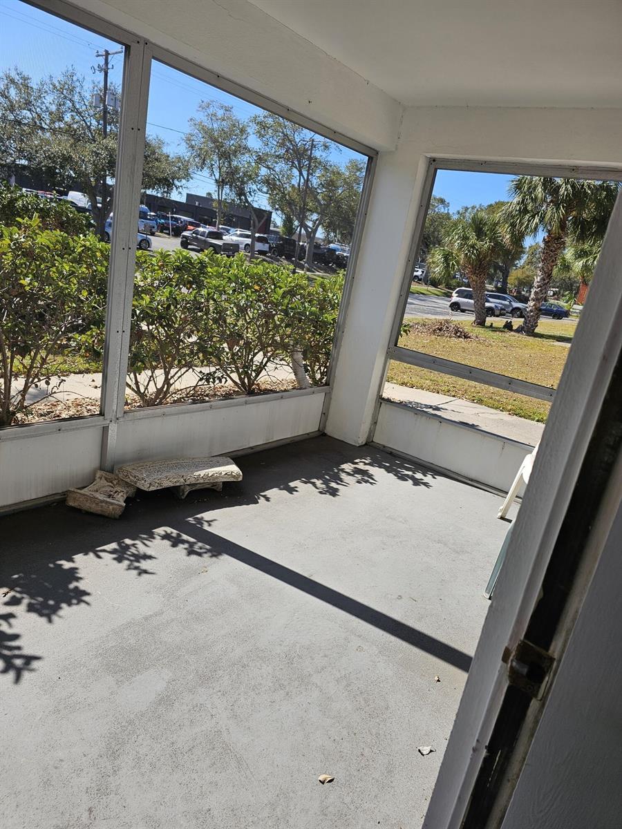 A screened-in porch with a concrete floor, white framing, and a view of a parking lot — 2348 Shelley Street # 1, Clearwater FL 33765, CLEARWATER, FL