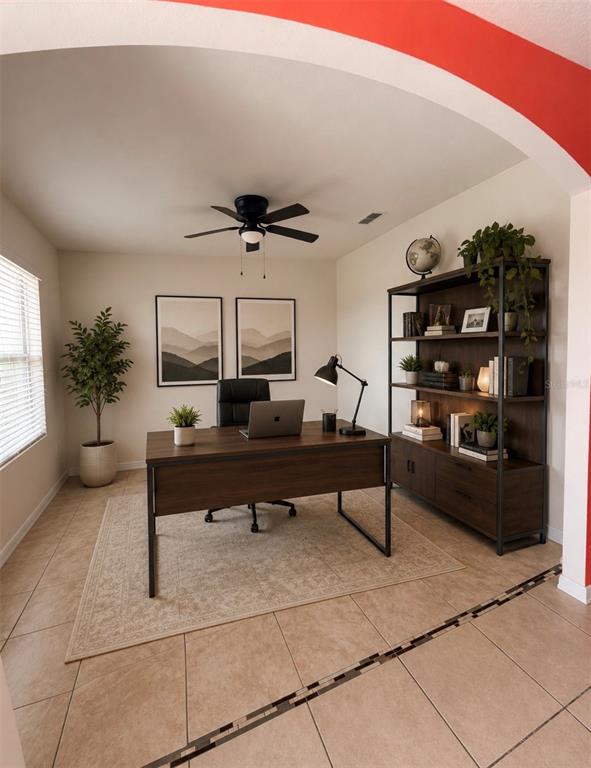 A home office features a dark wood desk, matching bookshelf, ceiling fan, and tile flooring — 885 FREEDOM BOULEVARD, DAVENPORT, FL