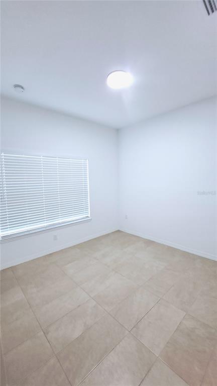 An empty room with white walls, tile flooring, and a window with white blinds — 3 EASTERN PLACE UNIT A, PALM COAST, FL