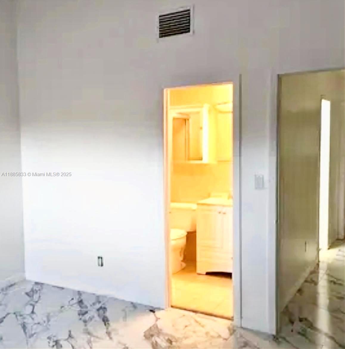 A room with marble-patterned tile flooring leads into a small bathroom with a vanity — 5164 S University Dr, Davie FL 33328, DAVIE, FL