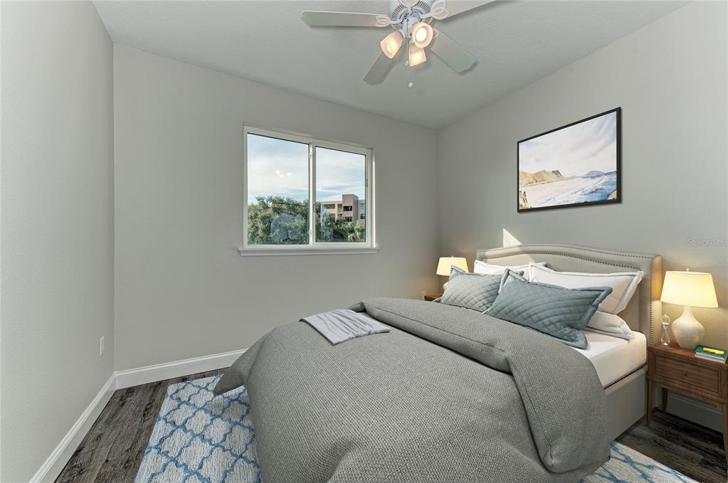 A bedroom features a bed with gray bedding, a ceiling fan, and a window — 2225 14TH AVENUE W UNIT 201, PALMETTO, FL