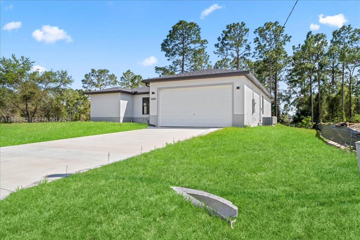 A single-story house with a white stucco exterior and a two-car garage — 2914 67th st W, Lehigh Acres FL 33971, LEHIGH ACRES, FL