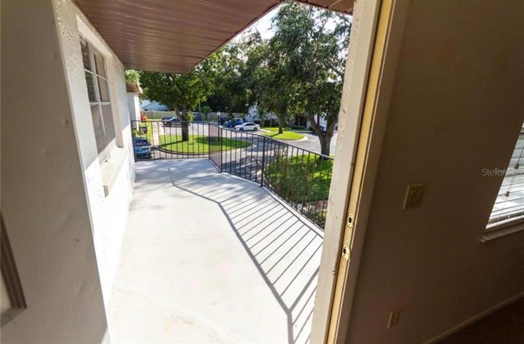 A view from a doorway looking out onto a covered balcony with a metal railing — 170 WINDTREE LANE, WINTER GARDEN, FL