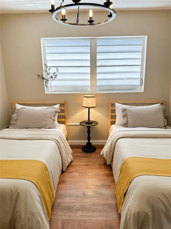 A bedroom features two twin beds with yellow runners and a central bedside lamp — bloque 24 CALLE JOSE SEVERO QUINONEZ, CAROLINA, PR