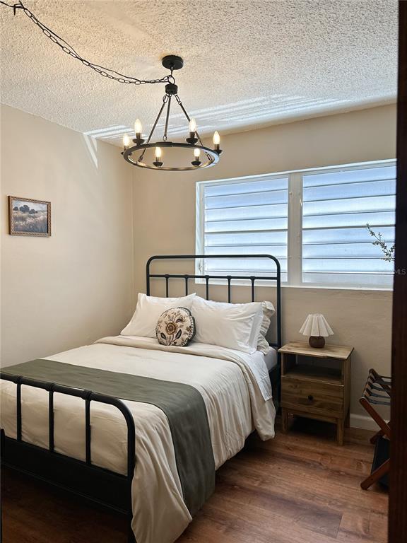 A bedroom features a black metal bed frame, a chandelier, and a wooden nightstand — bloque 24 CALLE JOSE SEVERO QUINONEZ, CAROLINA, PR