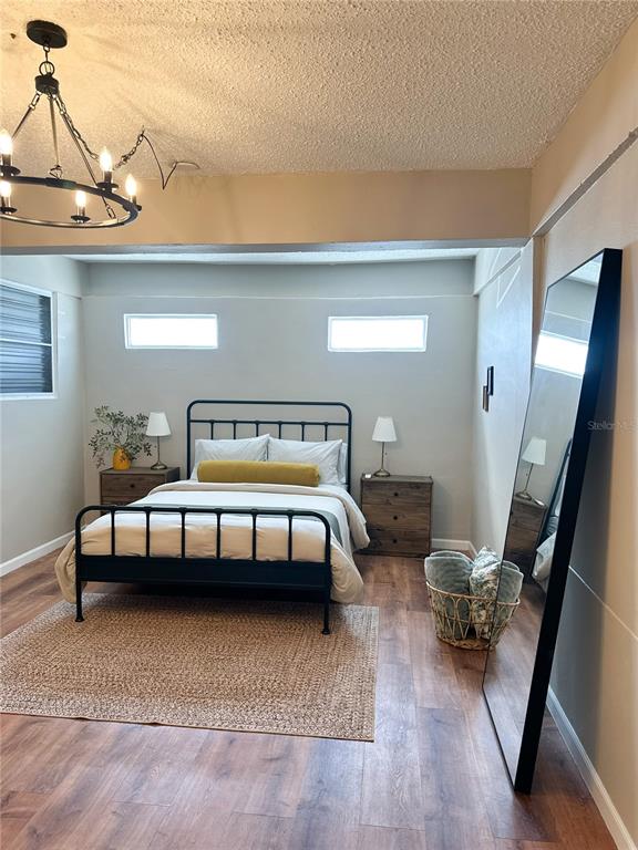 A bedroom features a black metal bed frame, wood-look flooring, and a large floor mirror — bloque 24 CALLE JOSE SEVERO QUINONEZ, CAROLINA, PR