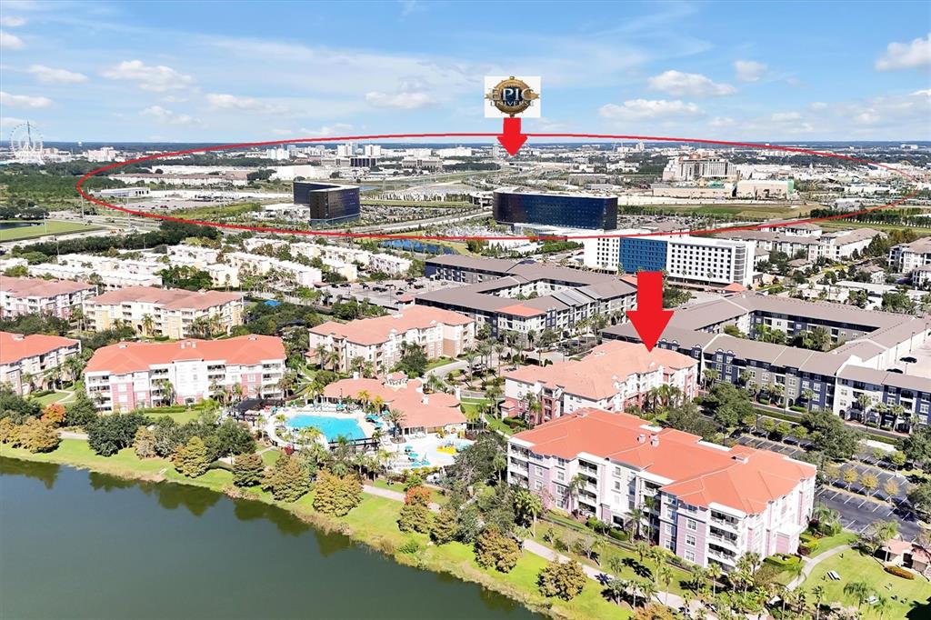 An aerial view shows a residential apartment complex with a pool near a large lake — 4862 CAYVIEW AVENUE UNIT 30809, ORLANDO, FL