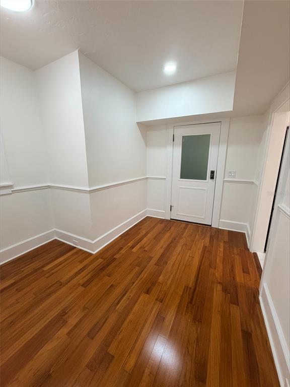 A room with white walls, wainscoting, and hardwood flooring features a door with frosted glass — 1221 N PALM AVENUE UNIT 204, SARASOTA, FL