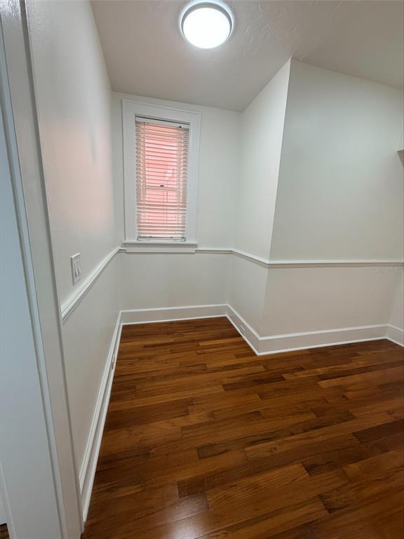 An empty room with white walls, chair rail molding, and dark hardwood flooring — 1221 N PALM AVENUE UNIT 204, SARASOTA, FL