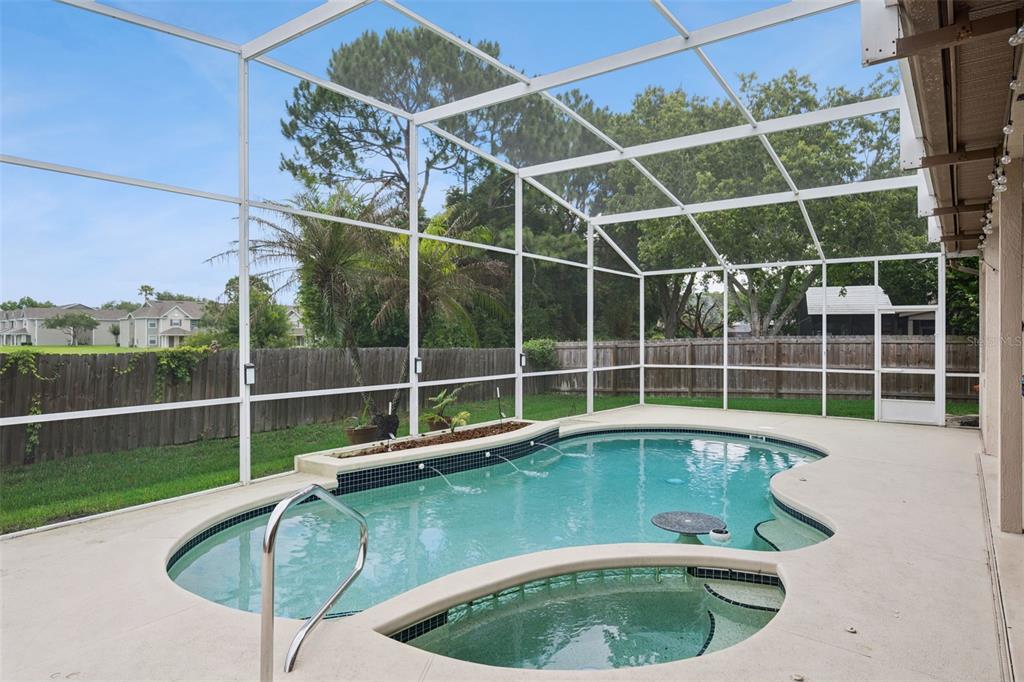 A screened-in patio features a swimming pool with a built-in spa and water fountains — 632 TERRACE COVE WAY, ORLANDO, FL